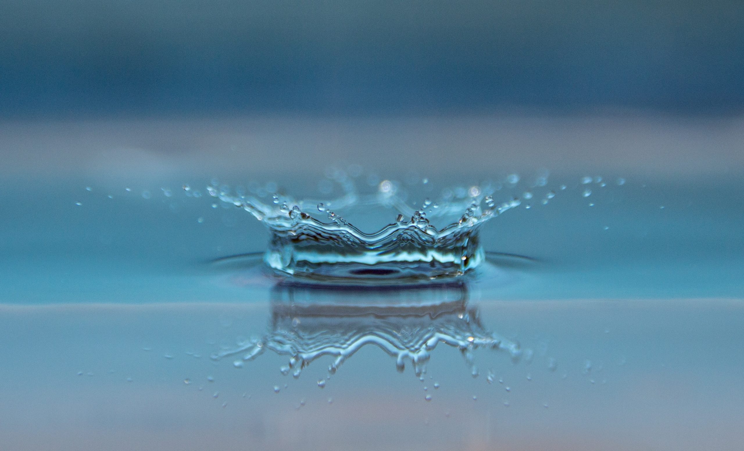 Une goutte d'eau qui éclate à la surface d'un lac, connotant la numérologie stratégique et la connaissance de soi.